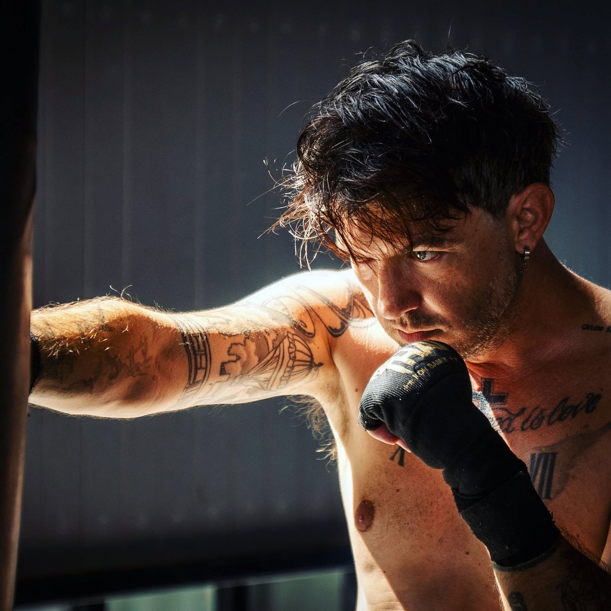 Carl Tomich training with boxing gloves in a gym