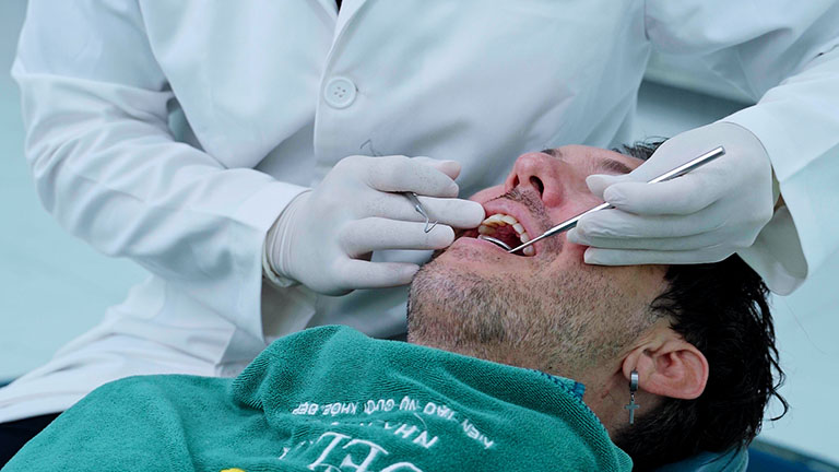 Hanoi dentist checking Carl Tomich's teeth during treatment