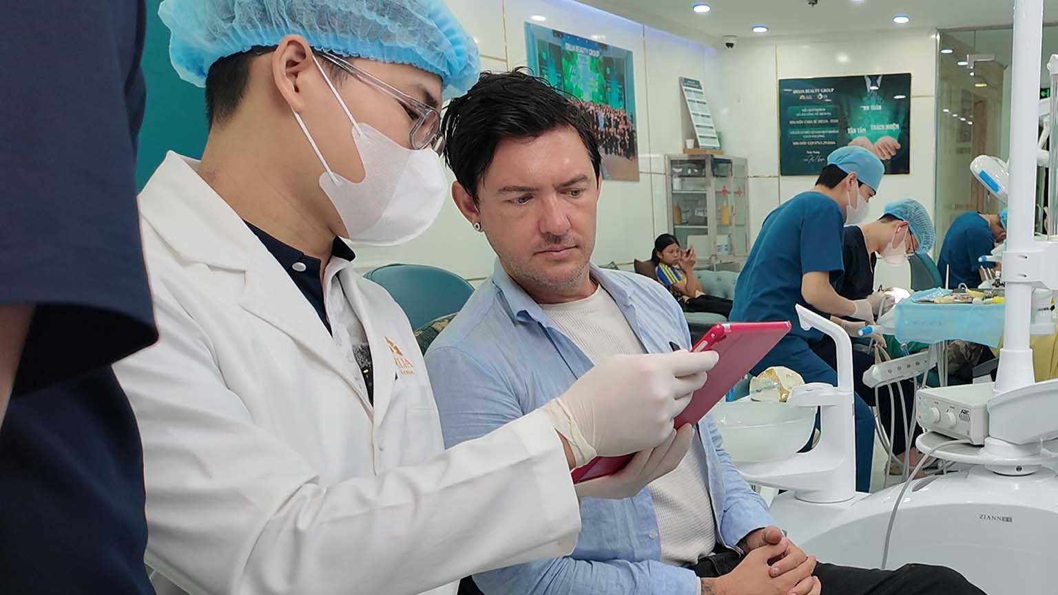 Dentist in Hanoi explaining treatment planning to Carl Tomich